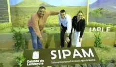 Samuel Martín, Oswaldo Betancort y Nori Machín señalando el cartel que determina el valor de las acciones relacionadas con el sector primario en Lanzarote