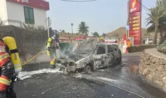 Imagen del vehículo totalmente calcinado a escasos metros de la gasolinera