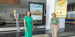 Olivia Duque y Rita Hern&aacute;ndez junto a un cartel promocional de Teguise.