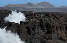 Personas en la zona de los Hervideros durante el fuerte oleaje.