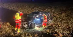 Bomberos junto al veh&iacute;culo accidentado.