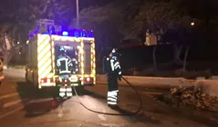 Bomberos del Consorcio de Seguridad y Emergencias apagando las llamas en un contenedor.
