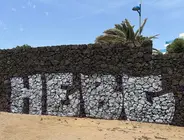 Imagen de una de las pintadas gigantes que han hecho en la piedra volc&aacute;nica de la playa