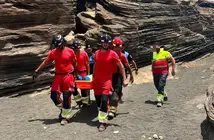Momento en el que los bomberos y los polic&iacute;as locales trasladan a la persona herida.