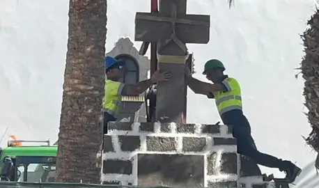 Momento en el que los operarios de la empresa Tiagua colocaron de nuevo la cruz en la plaza.