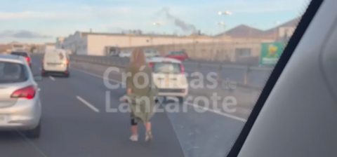Mujer circulando por en medio de la autov&iacute;a de Playa Honda.