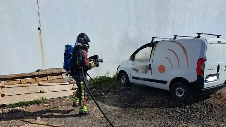 Bombero apagando el fuego localizado en el interior del vehículo.