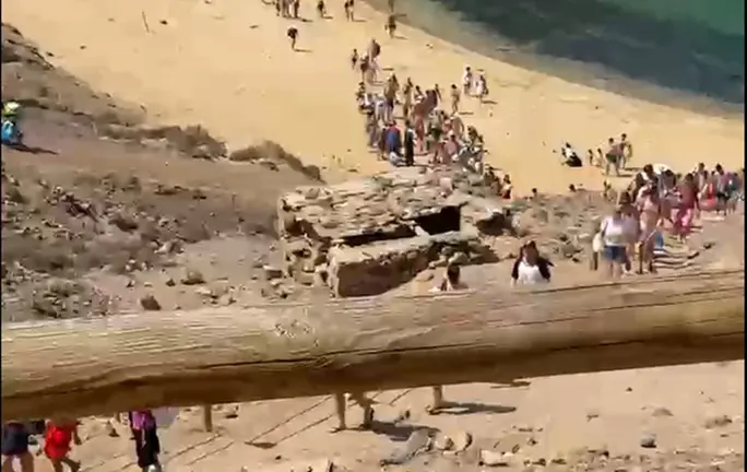 Desalojo de las personas de la playa de Papagayo tras el vertido provocado por la caída de un camión.