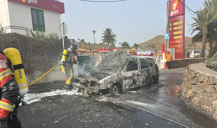Imagen del vehículo totalmente calcinado a escasos metros de la gasolinera
