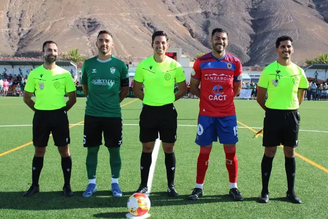Imagen de los dos equipos con el trío arbitral.