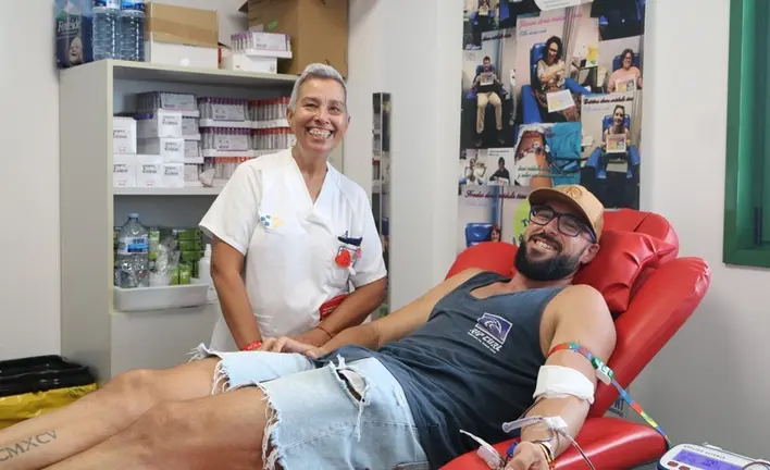 Donante de sangre junto a una sanitaria durante la extracción.