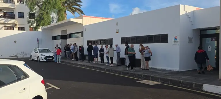 Imagen de la gente haciendo cola para entrar en el consultorio local.