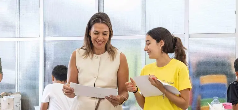 La concejal Maite Corujo con una de las alumnas viendo los trabajos.