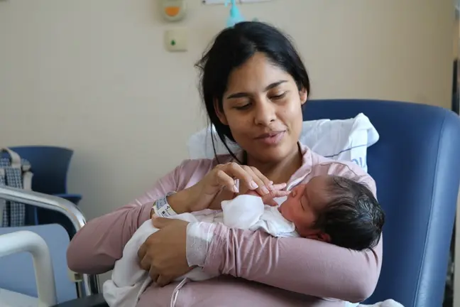 Madre junto a uno de los ni&ntilde;os nacidos en 2025.