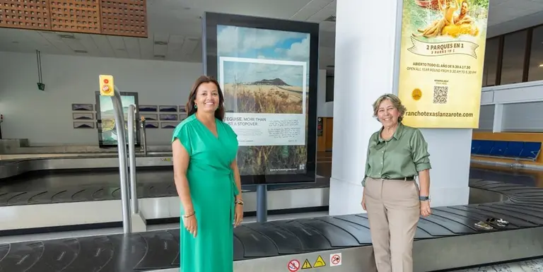 Olivia Duque y Rita Hern&aacute;ndez junto a un cartel promocional de Teguise.
