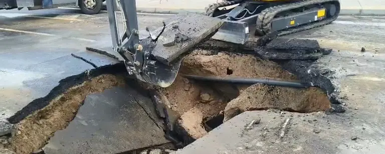 Pala excavadora abriendo un agujero donde se encuentra la tuber&iacute;a afectada.