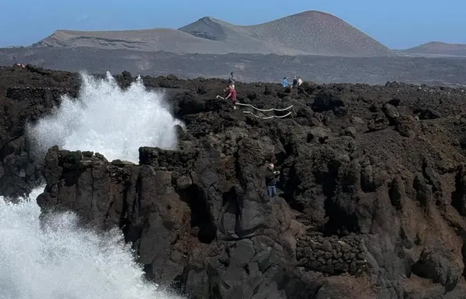 Personas en la zona de los Hervideros durante el fuerte oleaje.