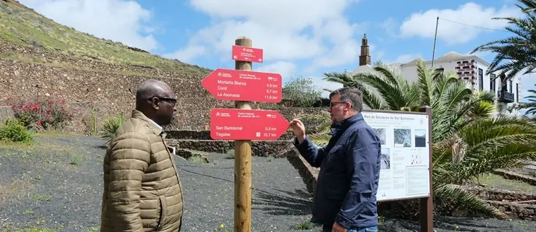 Isidro P&eacute;rez junto a Mamadou Yero Sy Ciss&eacute; observando la carteler&iacute;a de senderos municipales.