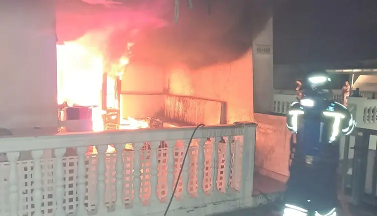 Bombero del Consorcio de Seguridad y Emergencias sofocando las llamas dentro de la vivienda.