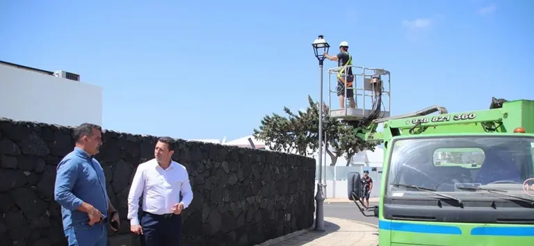 &Oacute;scar Noda y &Aacute;ngel Lago junto a los operarios colocando farolas en Yaiza.