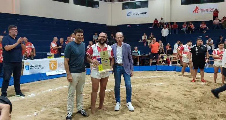 El representante de Caja 7 con el presidente de la Federaci&oacute;n Canaria de Lucha entregando el galard&oacute;n al capit&aacute;n del equipo vencedor