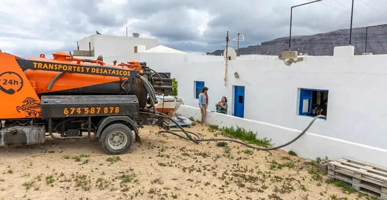 Olivia Duque junto a una vecina durante las labores de vaciado de Pozos Negros en La Graciosa.