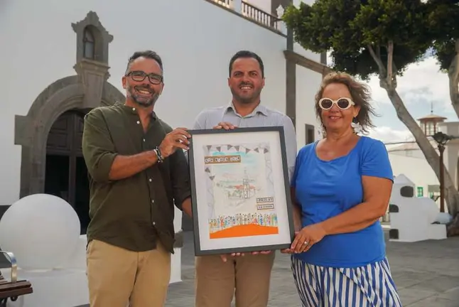 Echedey Eugenio y Yonathan de Le&oacute;n junto al cartel de San Gin&eacute;s y la artista que lo realiz&oacute;.