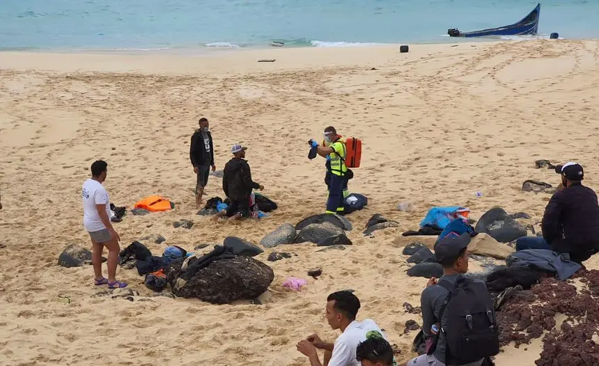 Imagen de los inmigrantes en la playa siendo atendidos por personal de Emerlan.