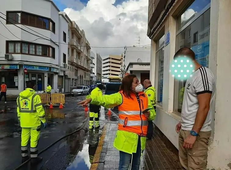 La alcaldesa de Arrecife, Astrid Pérez, habla con uno de los vecinos afectados por las inundaciones en la calle Portugal, en el 2020.