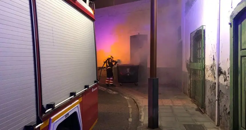 Instante en el que el bombero consiguió atajar el fuego del contenedor