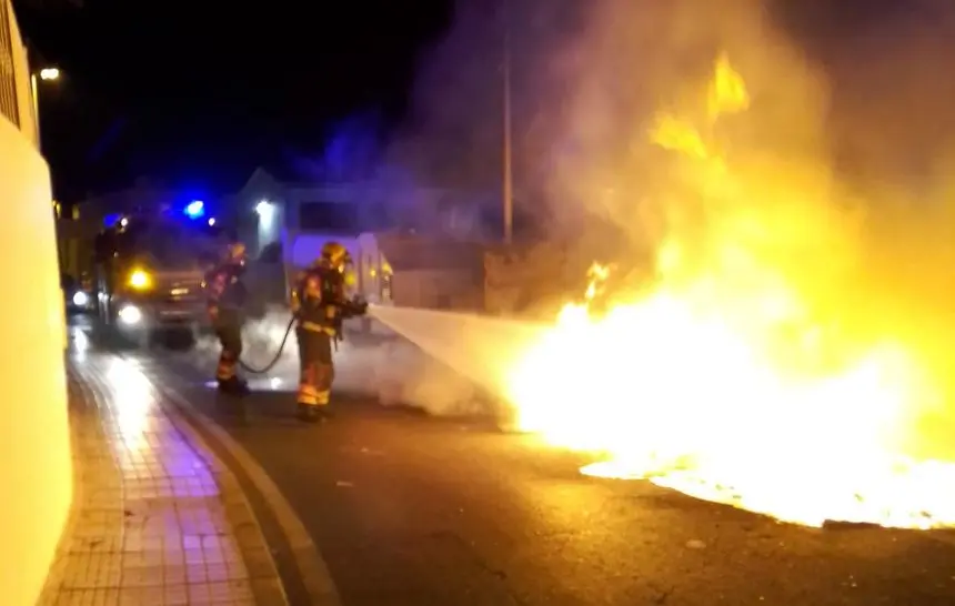 Momento en el que los bomberos tratan de sofocar el incendio cerca de una zona habitada