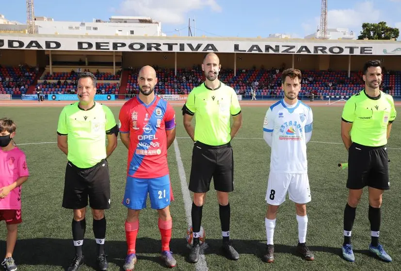 Imagen de la presentación de los dos equipos y el trío arbitral