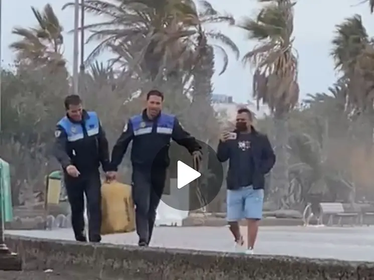 Momento en el que los dos agentes de la Policía Local trasladaban el fardo.