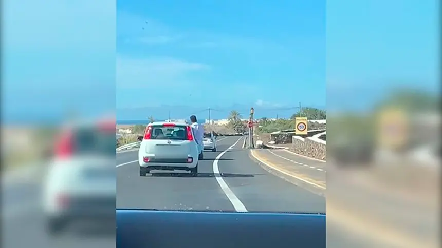 Imagen del pasajero con medio cuerpo fuera del coche.