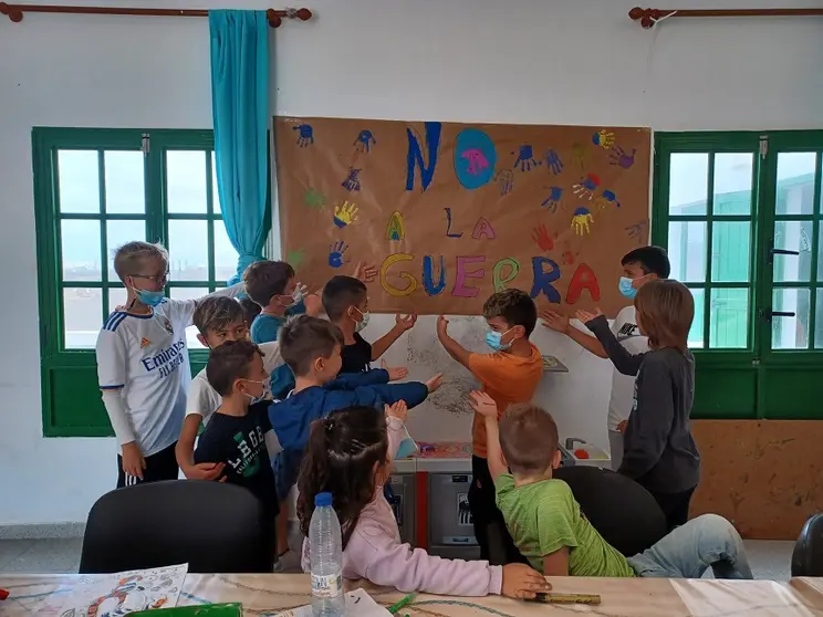 Niños de Tinajo junto al mural que realizaron contra la guerra de Ucrania.