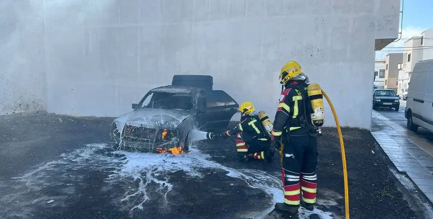 Los bomberos en el momento de apagar el fuego del vehículo.