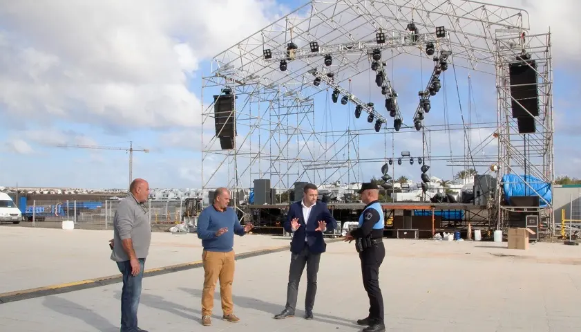 Oscar Noda y Javier Camacho junto a un componente de la polícía local de Yaiza en la plaza donde se desarrollaran los actos del carnaval.