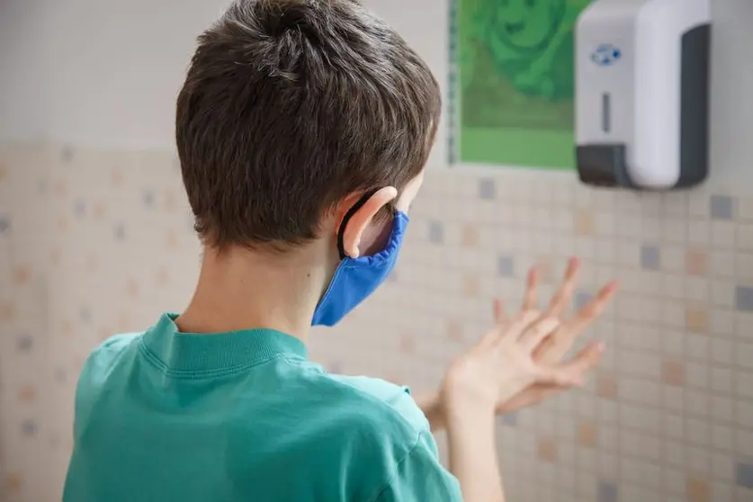 Niño con mascarilla dentro d eun centro educativo.