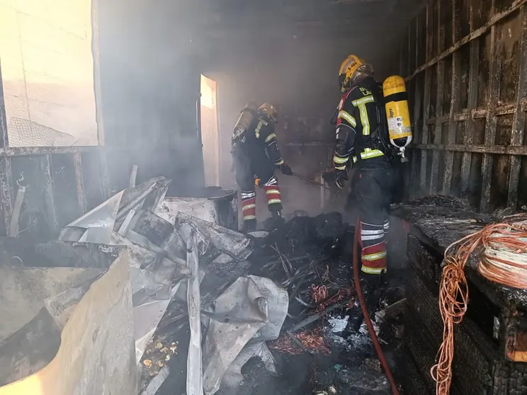 Bomberos del Consorcio extinguiendo el fuego dentro del contendor de obra.