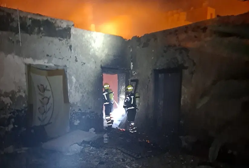 Bomberos durante su servicio en la vivienda abandonada.