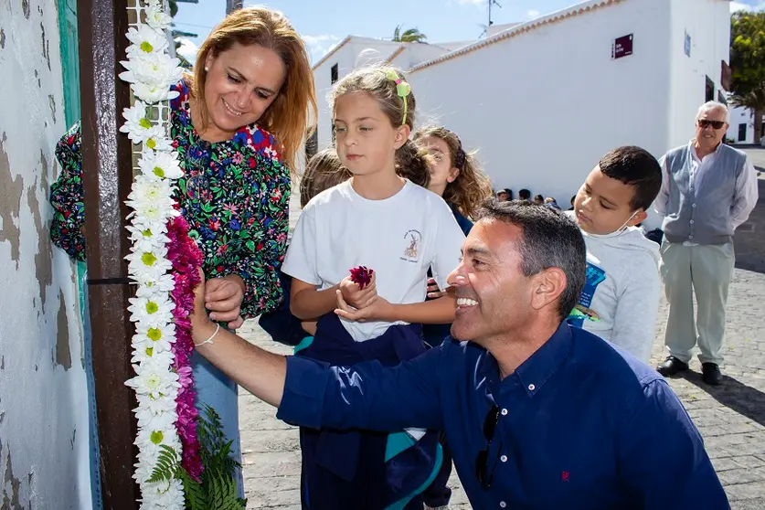 Oswaldo Betancort, alcalde Teguise, y Nori Machín, concejala de Cultura, junto a una niña colocando flores en una cruz.