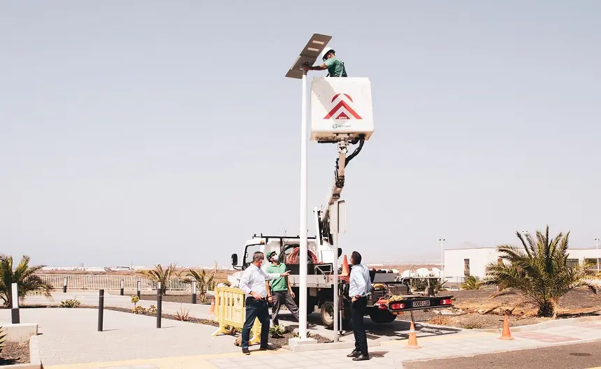 Oswaldo Betancort y Eugenio Robayna junto a un operario realizando las labores de instalación del alumbrado público.