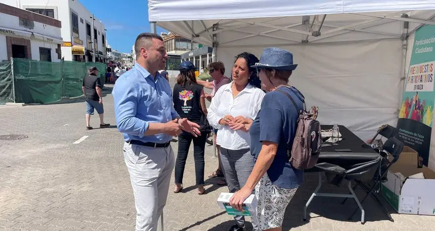 Óscar Noda charlando con unos vecinos en Playa Blanca.