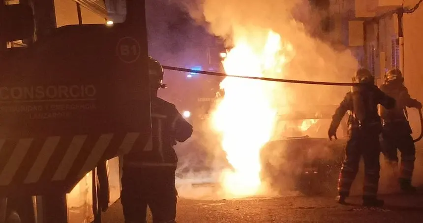 Momento de la peligrosa actuación de los bomberos con las llamas casi alcanzando a una de las viviendas