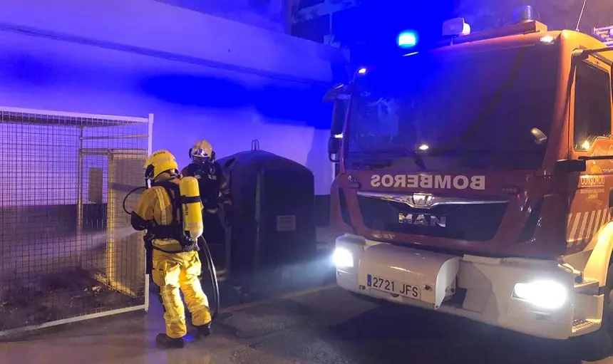 Los bomberos durante su actuación para sofocar el incendio del contenedor.