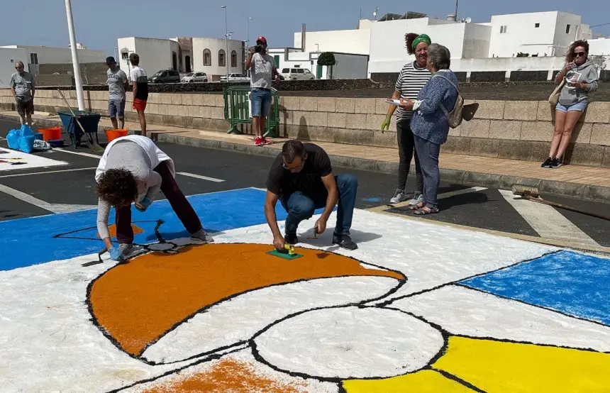 Imagen de gente trabajando en una de las tradicionales alfombras de sal.