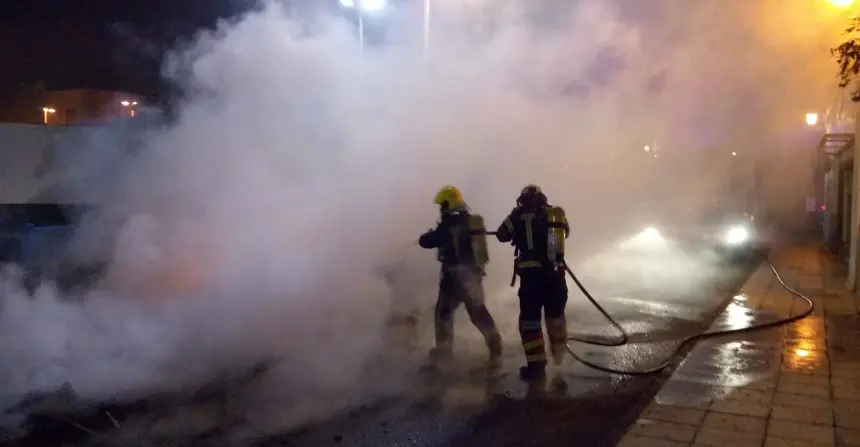 Imagen de los bomberos actuando en el incendio de tres contenedores en las cuatro esquinas.