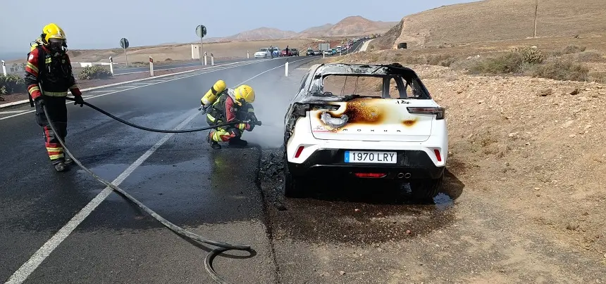 Imagen de los bomberos extinguiendo el fuego en el coche.