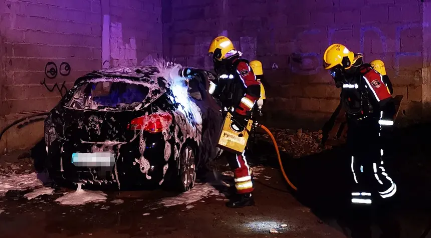 Imagen de los bomberos sofocando el fuego dentro del vehículo.