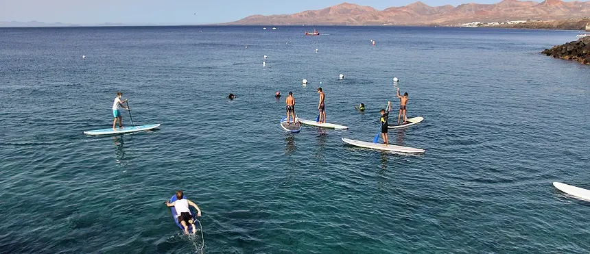 Imagen de gente realizando paddle surf en Puerto del Carmern.